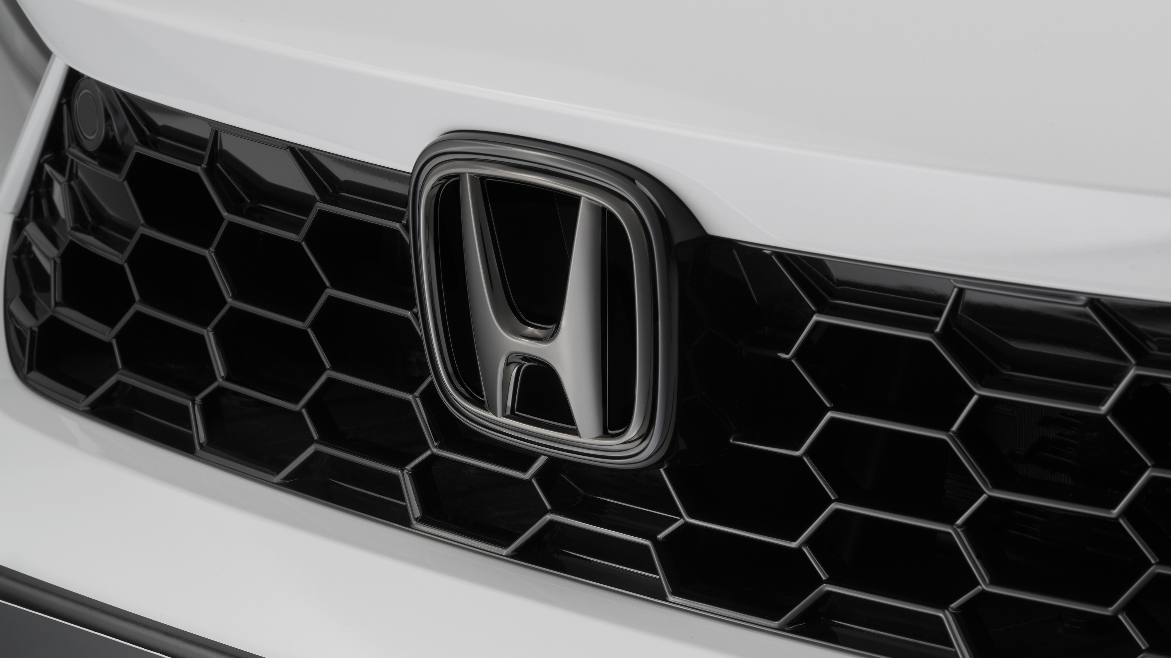 Közelkép a Honda emblémájáról a Civic Hybrid modellen.